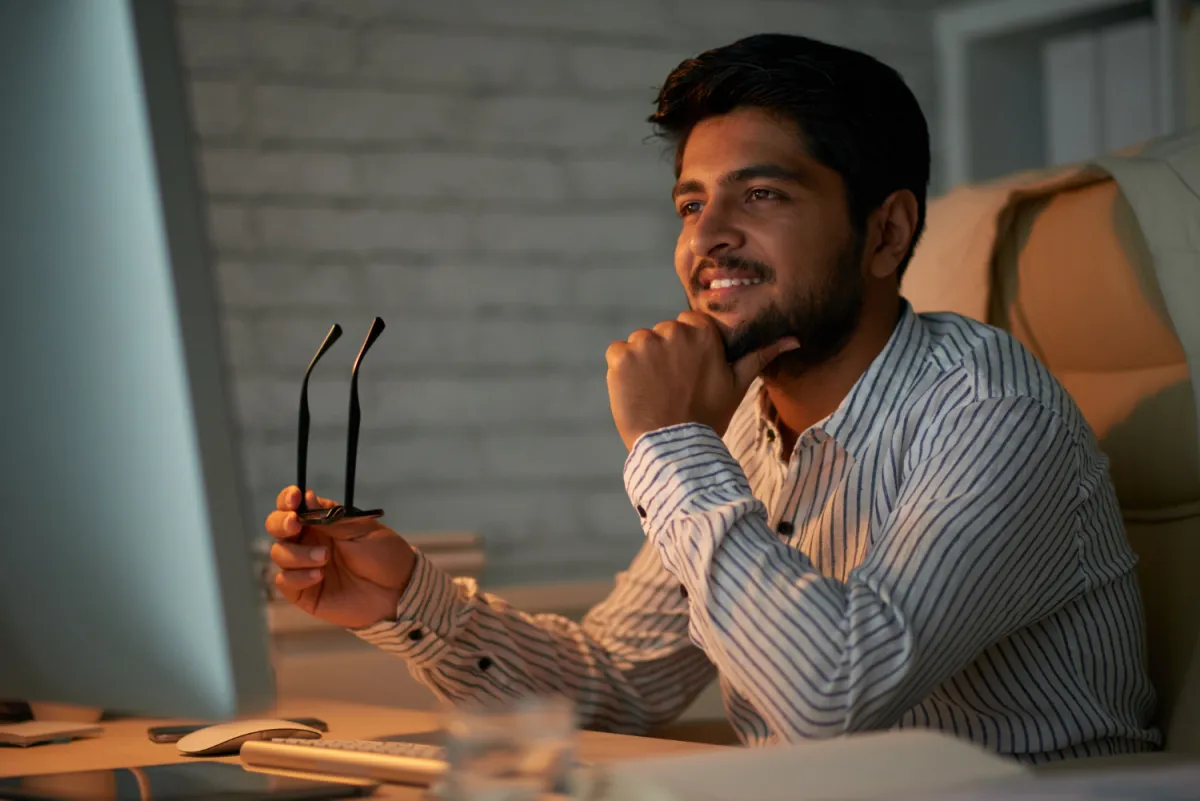 software development manager in an office with orange glow staring at computer screen conducting an interview