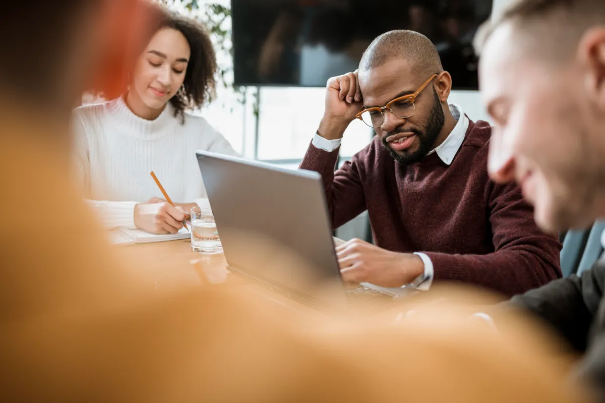 a team around a meeting table wondering what hiring questions to ask in a brainstorming session